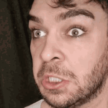 a man with a beard is making a funny face with his mouth open