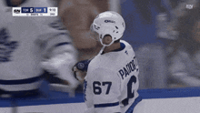 a hockey player with the number 67 on his jersey stands on the ice