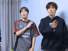 a boy wearing a shirt that says " fearless " stands next to another boy