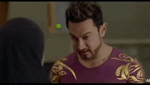 a man wearing sunglasses talks to a woman in a hijab