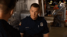 two police officers are talking to each other in a room .