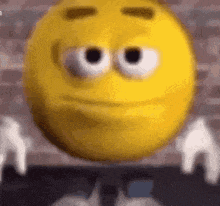 a close up of a yellow smiley face with big eyes and white wings .