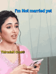 a woman in a pink dress is holding a cell phone with a caption that says i 'm not married yet