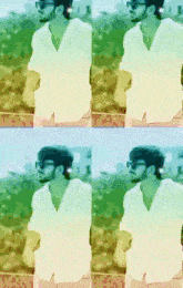 a man wearing sunglasses and a white shirt stands in front of a field