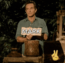 a man holding a sign that says mark