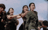 a group of people are dancing and one of them is wearing a jacket that says army on it