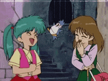 two girls are laughing in front of a bird
