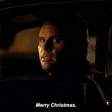 a man in a car says merry christmas on the screen
