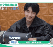 a man sitting in front of a sign that says " no push "