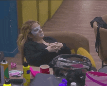 a woman with a mask on her face is sitting on a chair