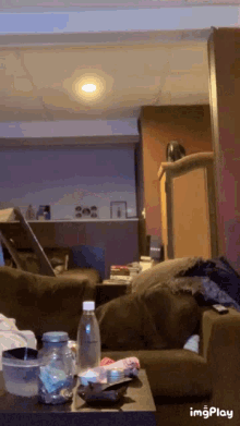 a bottle of water sits on a table in a living room next to a couch