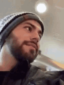 a man with a beard wearing a beanie and a jacket that says patagonia