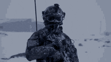 a soldier wearing a helmet and goggles holds a gun