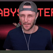a man wearing a hat and headphones is making a funny face in front of a video game screen .