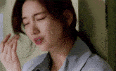 a close up of a woman 's face with her eyes closed and a hand on her face .