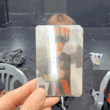 a person is holding a card with a picture of a man and the word wings on it