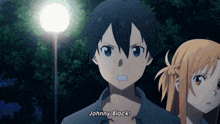a boy and a girl are standing next to each other in a dark room .