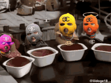 a group of people wearing ski masks are sitting at a table with bowls of liquid
