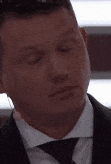 a man in a suit and tie is looking down