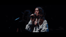 a man playing a guitar and a woman singing into a microphone on a stage