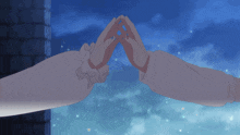 a couple of hands making a heart shape with a blue sky behind them