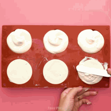 a person is using a spatula to spread frosting in a silicone tray that says easy plus on the bottom