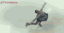 a woman in a white dress is doing a trick in front of a crowd and the words tvresidence are on the bottom