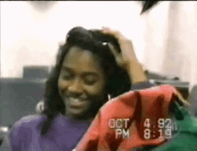 a woman is smiling in front of a screen that says oct 4 pm 8:19