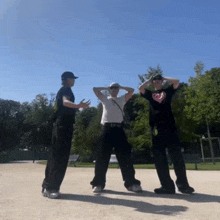 a man wearing a t-shirt with a heart on it is dancing with two other men
