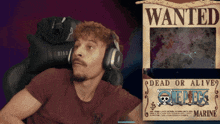 a man wearing headphones is looking at a wanted poster for one piece marine