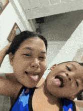 a woman and child sticking their tongues out together