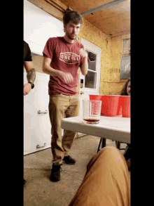 a man wearing an o'neill shirt is standing next to a table