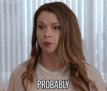 a woman is making a face and saying probably in front of a window .