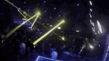 a crowd of people are dancing in a club with a lot of lights .