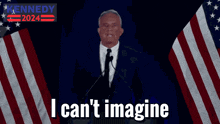 a man in a suit and tie stands in front of an american flag and says " i can t imagine "