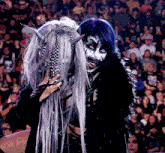 a woman with purple hair and horns is standing next to a woman with white hair and horns