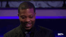 a man in a suit and tie is looking up at something in a dark room .