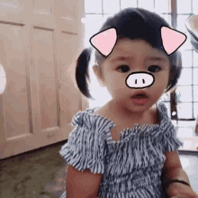 a little girl with pig ears on her face looks surprised
