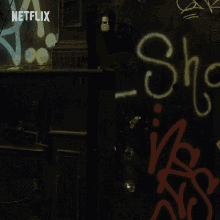 a man in a hooded jacket stands in front of a netflix sign