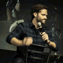 a man in a plaid shirt is holding a microphone in his hand