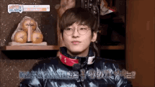 a young man wearing glasses and a black jacket is talking