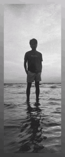 a man wearing a shirt that says always stands in the water