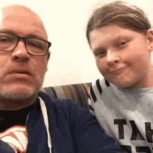 a man and a boy are sitting on a couch .