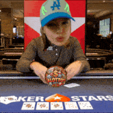 a woman sitting at a poker table with a lottery ball in front of her