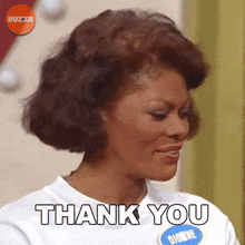a woman wearing a white shirt with the word thank you on it
