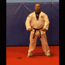 a man wearing a white karate uniform with a black belt that says martial arts