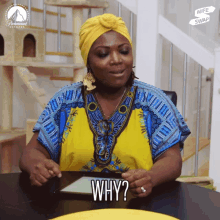 a woman sitting at a table with a tablet and the word why on her face