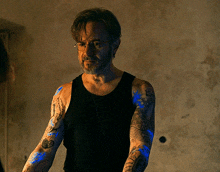 a man with a beard and tattoos on his arms