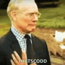 a man in a suit and tie is holding his hand to his chest and says `` thatscodd '' .