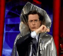 a man is wearing a silver cape with a large hood